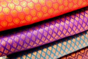 Colorful traditional silk fabrics from Kanchipuram, India, showcasing rich patterns and textures.